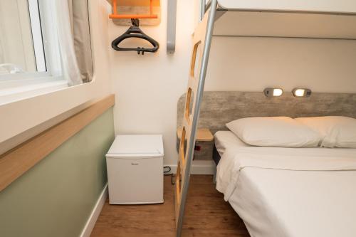 a small bedroom with two bunk beds and a window at ibis budget Campinas Aquidaban in Campinas