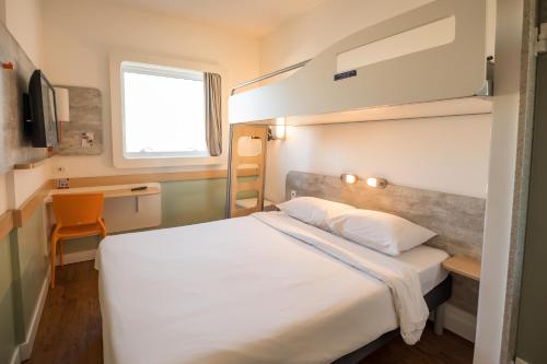 a bedroom with a large white bed and a window at ibis budget Campinas Aquidaban in Campinas