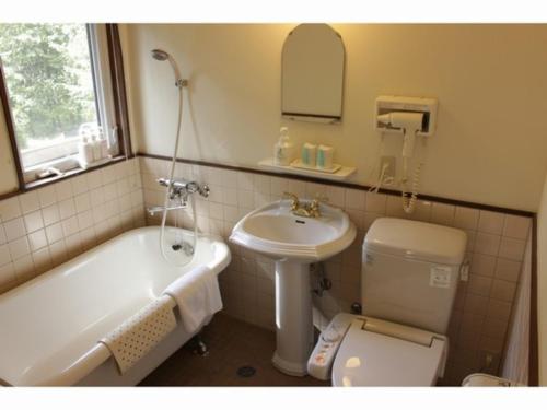 Gusthof Lumiere - Vacation STAY 41349v في فوجيكاواجوتشيكو: حمام مع حوض وحوض استحمام ومرحاض
