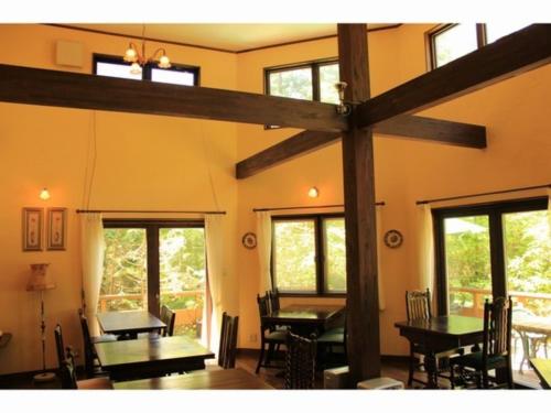 a dining room with tables and chairs and windows at Gusthof Lumiere - Vacation STAY 41349v in Fujikawaguchiko