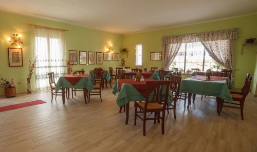 a dining room with tables and chairs and green walls at Villa Alberta Hotel in Pula