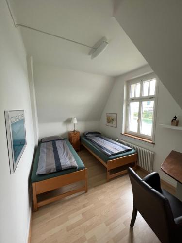 ein Schlafzimmer mit 2 Betten und einem Stuhl darin in der Unterkunft Charmante Altbauwohnung am Rhein in Basel