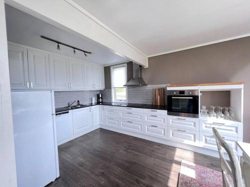 a large white kitchen with white cabinets and a sink at Moldegaard Farmhouse - Apartment C in Moldegard