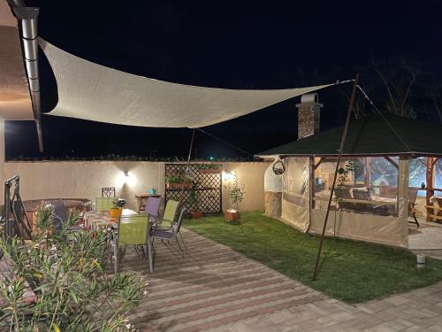 a tent in the yard of a house at night at Linett Apartman in Hajdúszoboszló