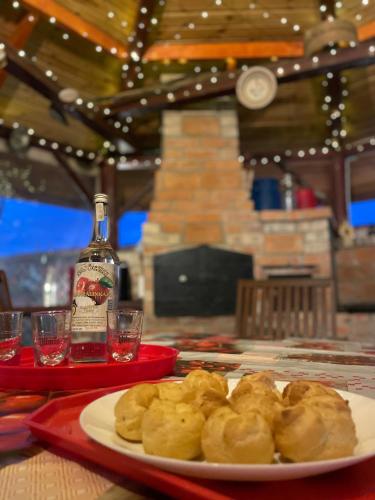 a plate of food on a table with a bottle of alcohol at Linett Apartman in Hajdúszoboszló