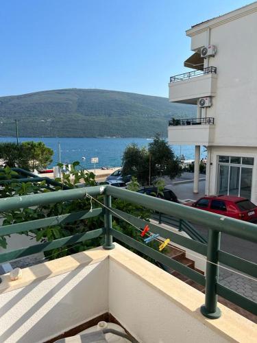 einen Balkon mit einem grünen Geländer neben einem Gebäude in der Unterkunft Milinovic apartmani1 in Herceg-Novi