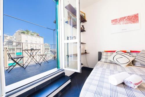 Zimmer mit einem Balkon, einem Bett und einem Fenster in der Unterkunft Home of Genoa's executioner in Genua
