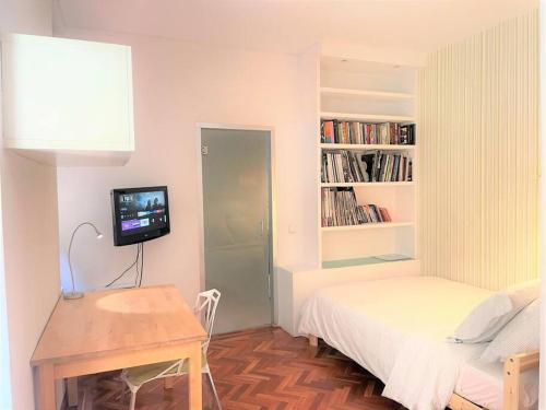 ein kleines Schlafzimmer mit einem Bett und einem TV in der Unterkunft Exclusivo y acogedor Apartamento en Chueca, Madrid con aire acondicionado in Madrid