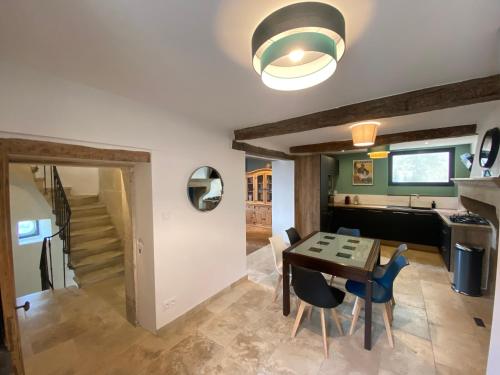 une cuisine et une salle à manger avec une table et des chaises dans l'établissement Authentique Maison de village avec Vue, à Réauville