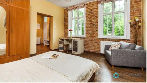 a bedroom with a bed and a brick wall at Apartament z Werandą w Dworku Oliwskim in Gdańsk