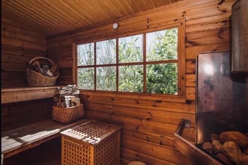 pokój z ławką i oknem w drewnianym domku w obiekcie Private lakefront property w mieście Söderköping