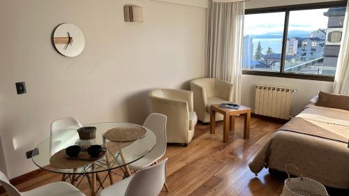 uma sala de estar com uma cama, uma mesa e cadeiras em Urban Patagonia Apart em San Carlos de Bariloche