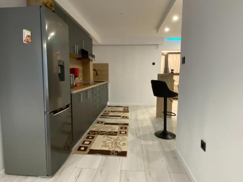 a kitchen with a refrigerator and a chair in it at Rozalia Apartman in Odorheiu Secuiesc