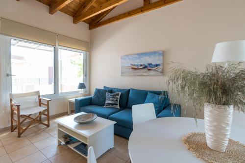 a living room with a blue couch and a table at Andreas House in Lixouri