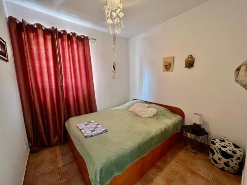 a bedroom with a bed and a red curtain at Milinovic apartmani3 in Herceg-Novi