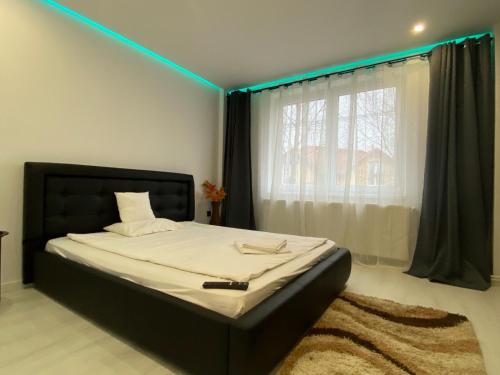 a bedroom with a bed with a blue light on it at Rozalia Apartman in Odorheiu Secuiesc