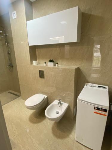 a bathroom with a white toilet and a sink at Good Vibes Apartment in Oradea