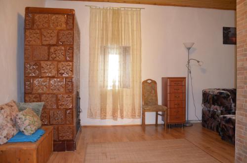 a living room with a couch and a window at Alföldi Vendégház in Hódmezővásárhely