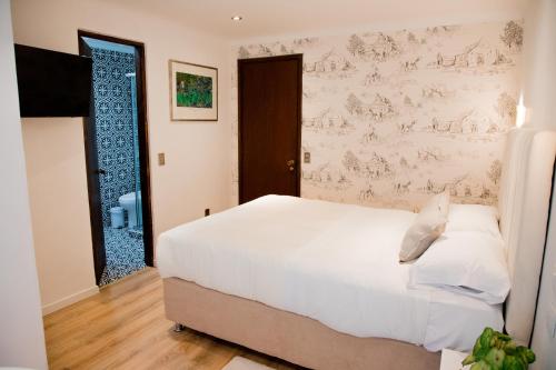 a bedroom with a large white bed with a wallpaper at Hotel Marcos Gamero in Talca
