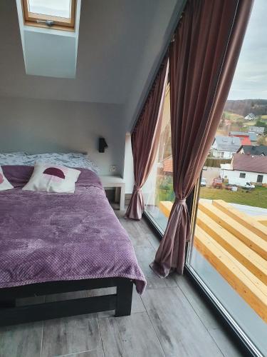 1 dormitorio con cama y ventana grande en Cienista Dolina 