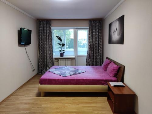 una camera con letto viola e finestra di Apartment on Victora Yarmoly a Kiev