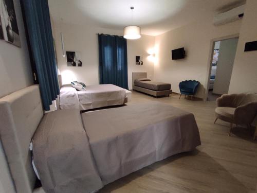 una camera d'albergo con due letti e un divano di B&B Villa Colomba a Agrigento