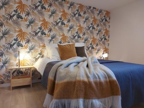 卡斯泰特的住宿－Les Landes With Love，一间卧室配有一张带蓝色被子和墙壁的床。