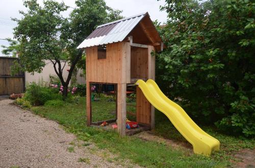 a small wooden play house with a slide at Alföldi Vendégház in Hódmezővásárhely