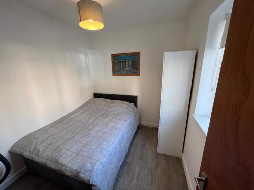 een kleine slaapkamer met een bed in een kamer bij A spacious flat in Cardiff