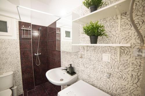 La salle de bains est pourvue d'un lavabo, de toilettes et d'une douche. dans l'établissement Chris & Mary Comfort Rooms 2, à Skála Neón Epivatón