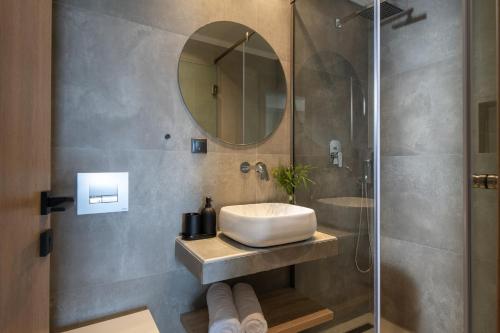 a bathroom with a sink and a mirror at Melian Suites in Nikiti