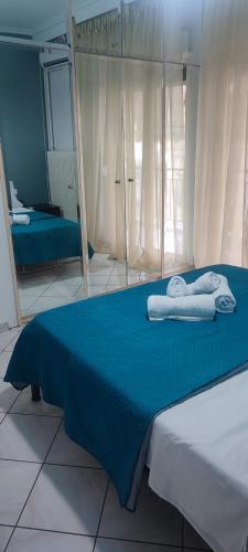 卡瓦拉的住宿－Valantis House，一间卧室配有蓝色的床和毛巾