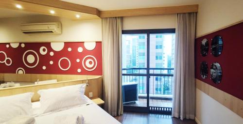a hotel room with a bed and a large window at Flat 4 estrelas a 1 quadra da Paulista nos Jardins in São Paulo