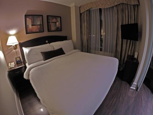A bed or beds in a room at Grand Hotel & Suites