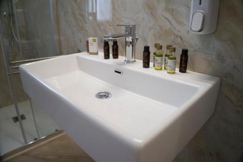 a white sink with bottles on it in a bathroom at B&B Villa Colomba in Agrigento