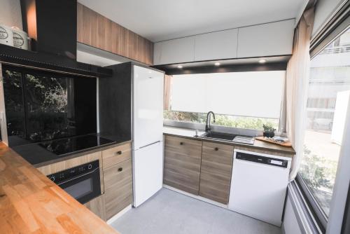 uma cozinha com electrodomésticos brancos e uma grande janela em T3- un Oasis rénové et climatisé au centre de LGM em La Grande-Motte