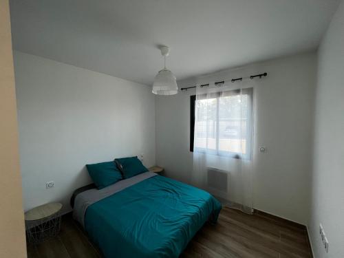 1 dormitorio con cama con sábanas azules y ventana en Maison en Provence, en Lançon-Provence