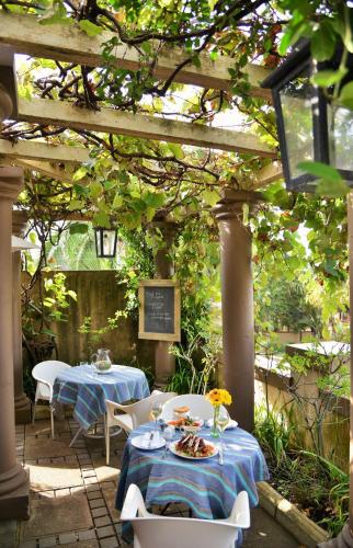 a patio with two tables and chairs under a pergola at The Vineyard on Ballito in Ballito