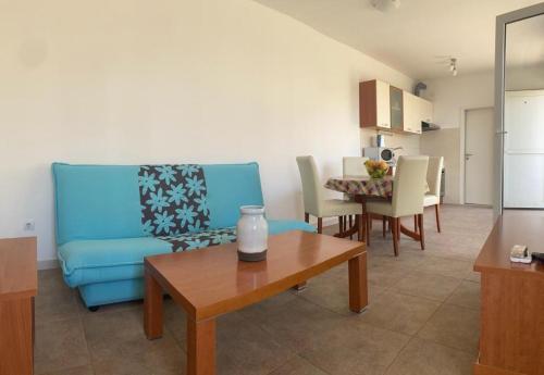 a living room with a blue couch and a table at Apartments Sunspot 1 in Lokva Rogoznica
