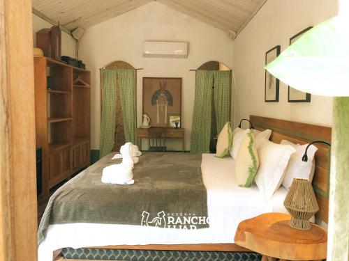 a bedroom with a large bed with green curtains at Pousada Rancho Luar in Pôrto de Pedras