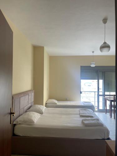 a bedroom with two beds and a table in it at Almar Apartments in Durrës