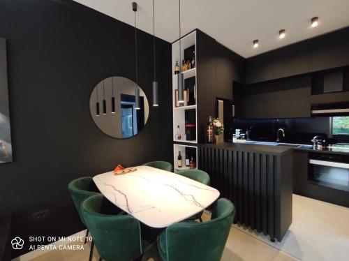 a dining room with a table and green chairs at Luxury City Center Cetinje Apartment in Cetinje