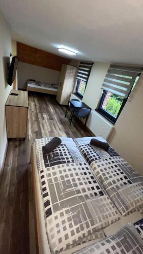 a bedroom with two beds in a room with a kitchen at Penzion Loket in Loket