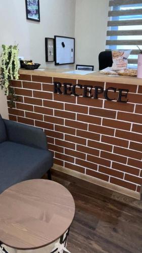 a bar with a brick wall and a table and a counter at Penzion Loket in Loket