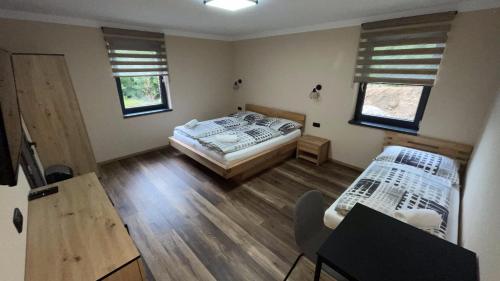 a bedroom with two beds and a table and chairs at Penzion Loket in Loket