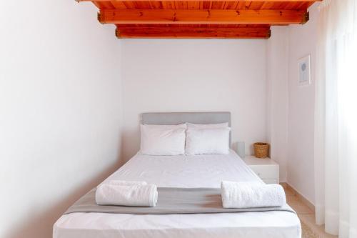 a small bedroom with a bed with white sheets at A & D Houses in Patra