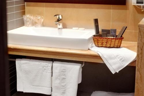 a bathroom counter with a sink and towels at Hotel Del Val in Andújar