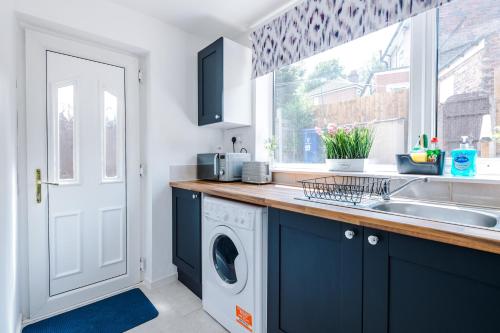 a kitchen with a sink and a washing machine at Modern 3-Bed house in Stoke by 53 Degrees Property, Ideal for Business & Long Stays - Sleeps 6 in Stoke on Trent