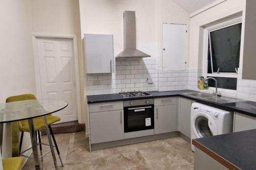 cocina con fogones, fregadero y lavavajillas en Two Bedroom Maisonette in Erith en Dartford