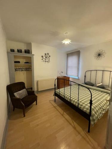 1 dormitorio con 1 cama y 1 silla en Two Bedroom Maisonette in Erith en Dartford